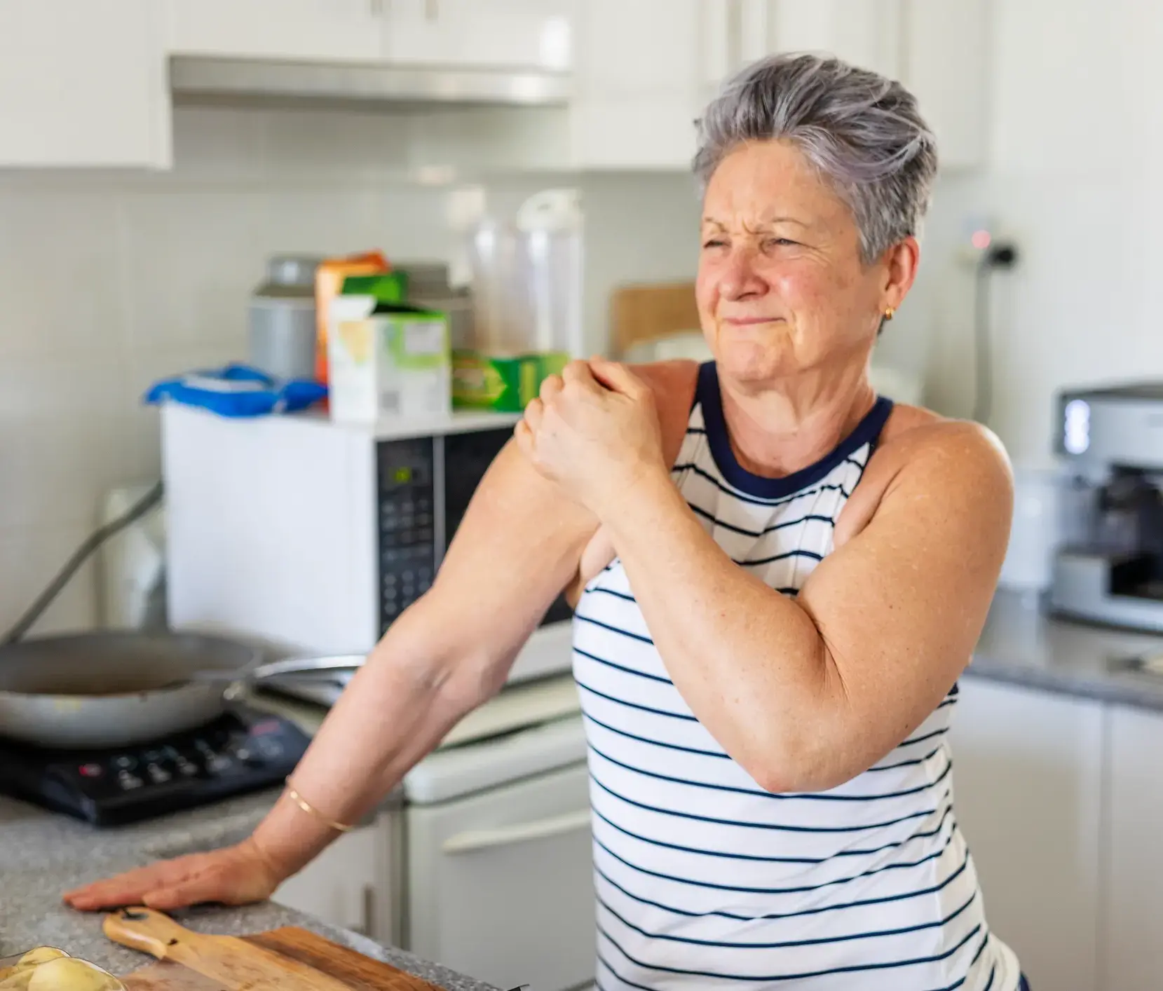 A woman in her Maryland home holds her arm to soothe her CRPS symptoms in her arm.