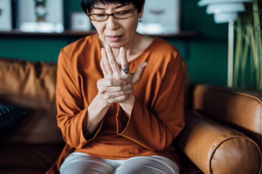 A woman holds her hand to relive joint pain from arthritis