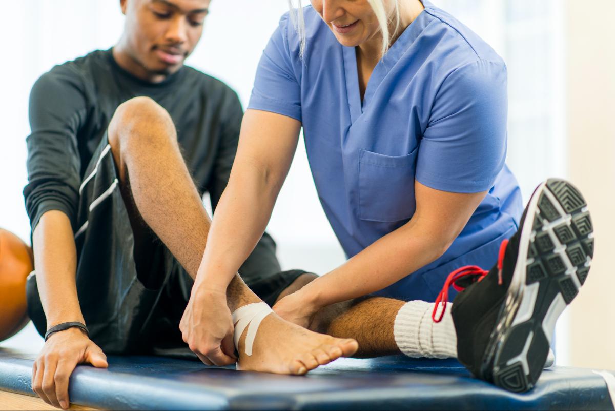 A doctor at Greater Maryland Pain Management examines the foot injury of a basketball player to determine the best treatment method.